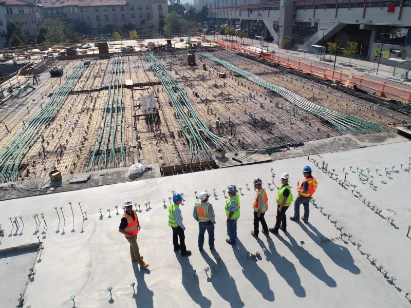 seven construction workers standing on white field